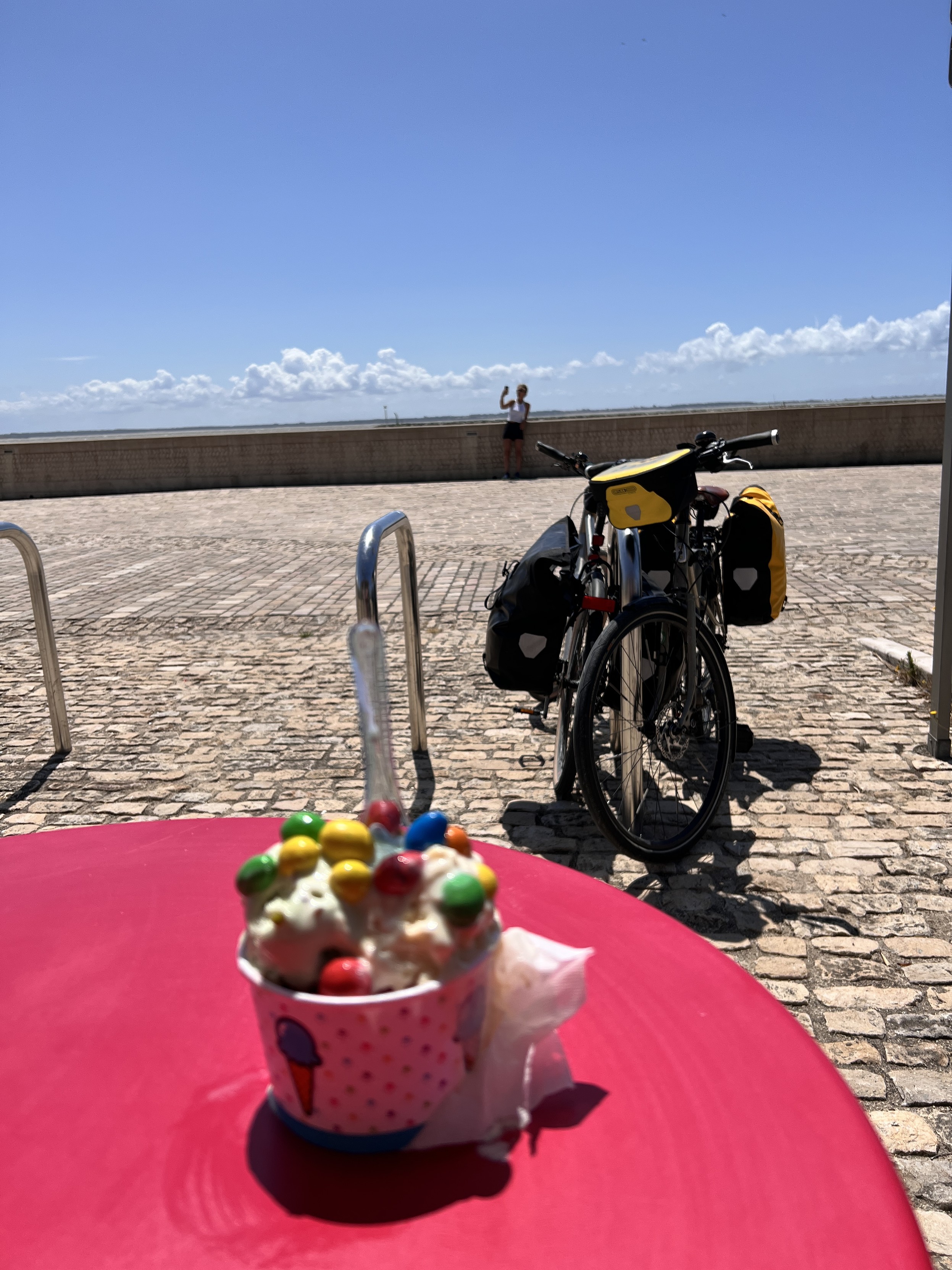 Une glace avec de M&M’s deux vélos et du ciel bleu au bord de la mer