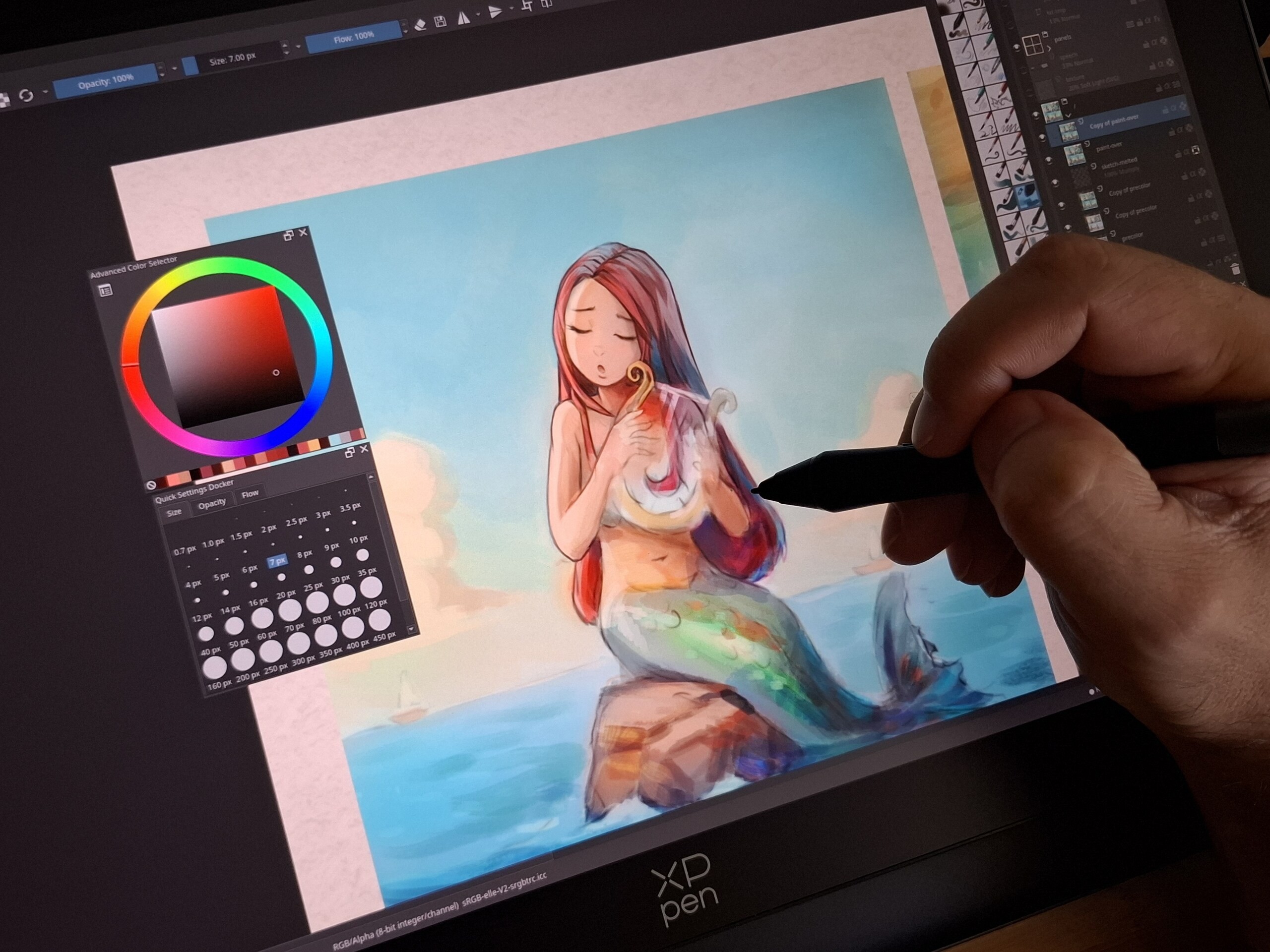 A shot of my hand with the stylus, while painting the first panel: a mermaid singing with a lyre on a rock in the middle of the ocean. I paint it on a display tablet, the XpPen Artist Pro 19 (gen2), the software is Krita appimage on Debian 12 KDE X11.