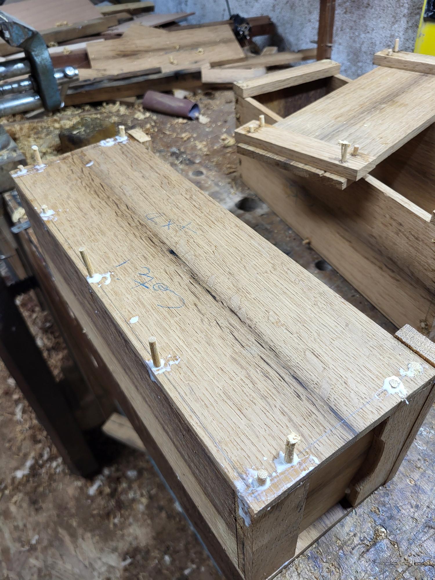 deux boites en bois en cours de collage avec des chevilles en bambou