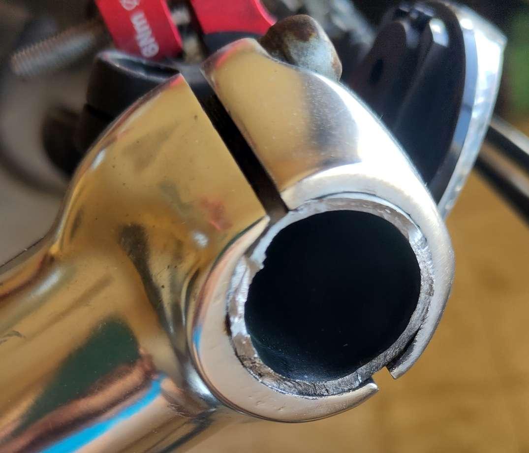 Une potence de vélo alu pour laquelle le cylindre du cintre qui en sort est brisé à ras.