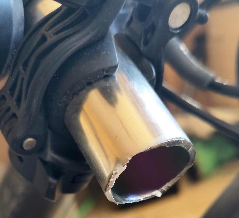 Le cylindre d’un cintre de vélo alu qui est brisé comme coupé. L’attache pour une lampe amovible y est encore attachée.